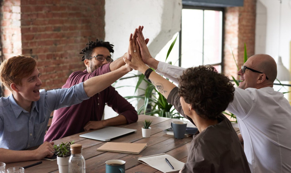 Getting Kanban Right From Day One Team celebrating success at a conference table