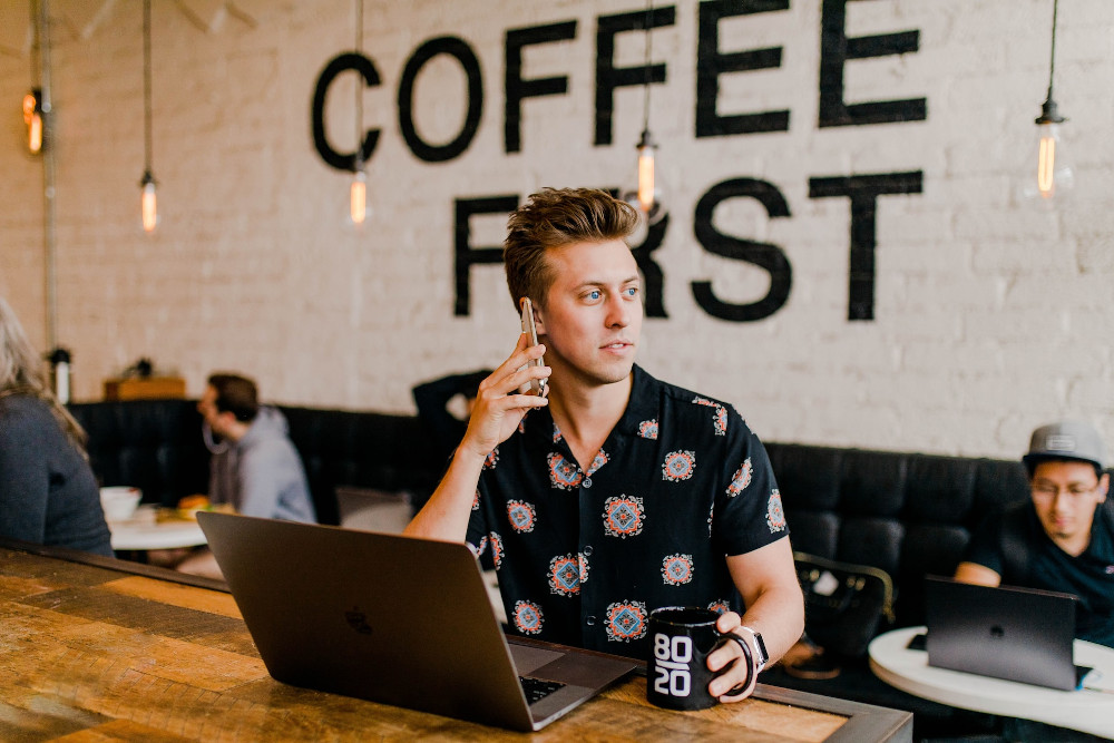 A man appears to be working from a cafe