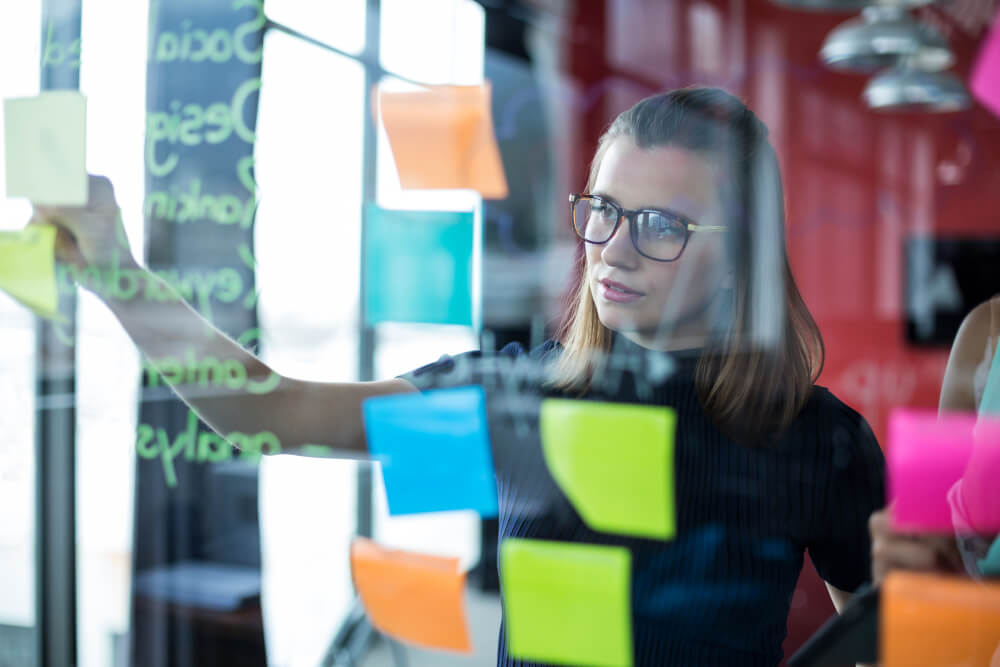 Woman making updates to a Kanban board