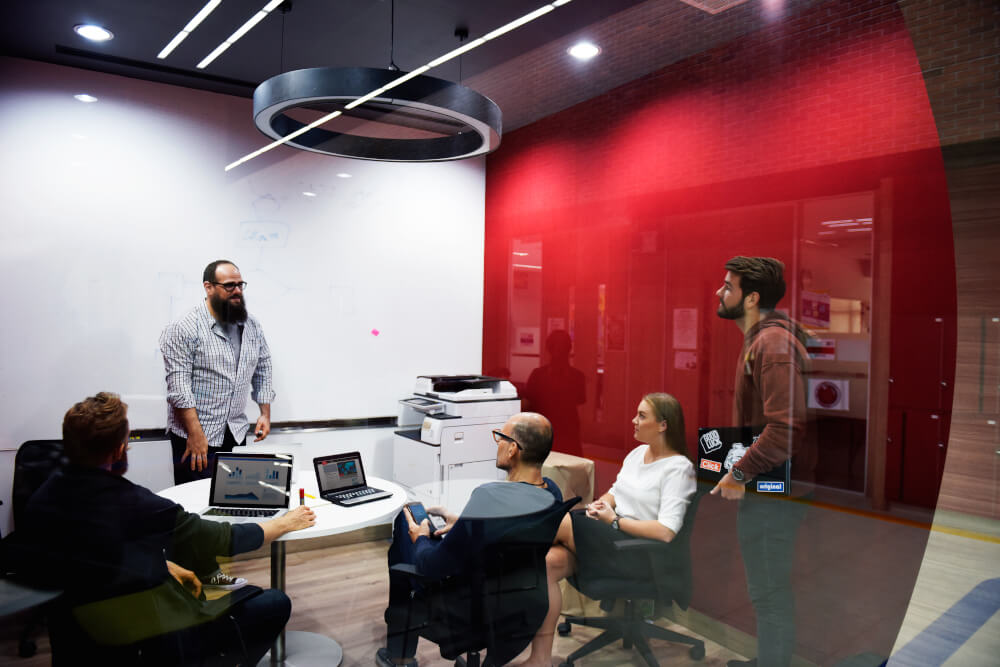 A manager is leading a small team meeting in his office