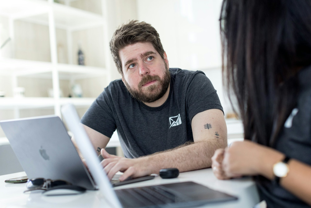 Colleagues discussing work in front of a laptop