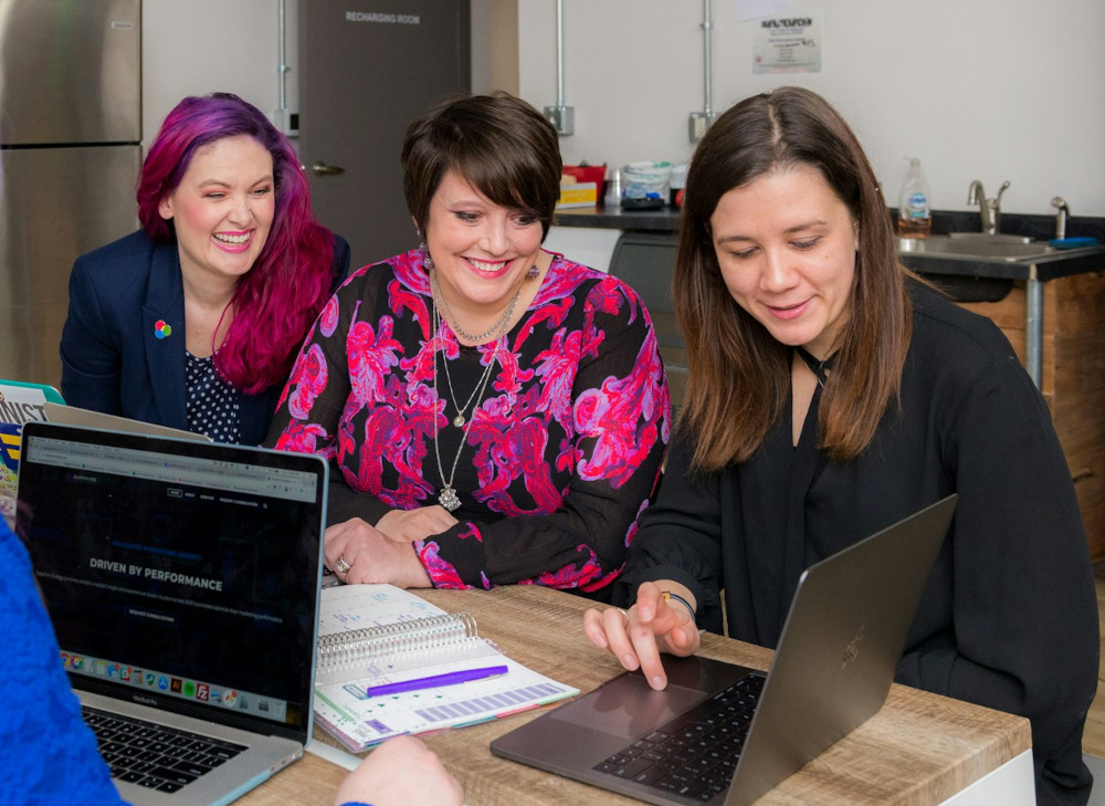 Colleagues joyfully discussing work at a conference table