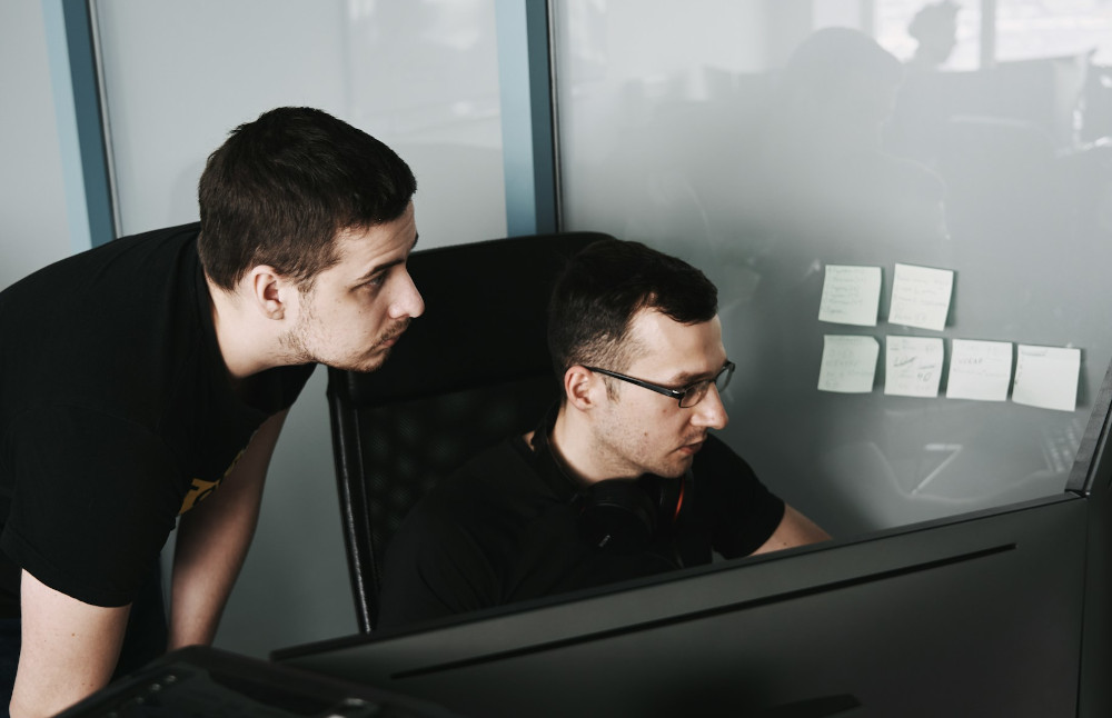 Colleagues focused on a PC screen at the office