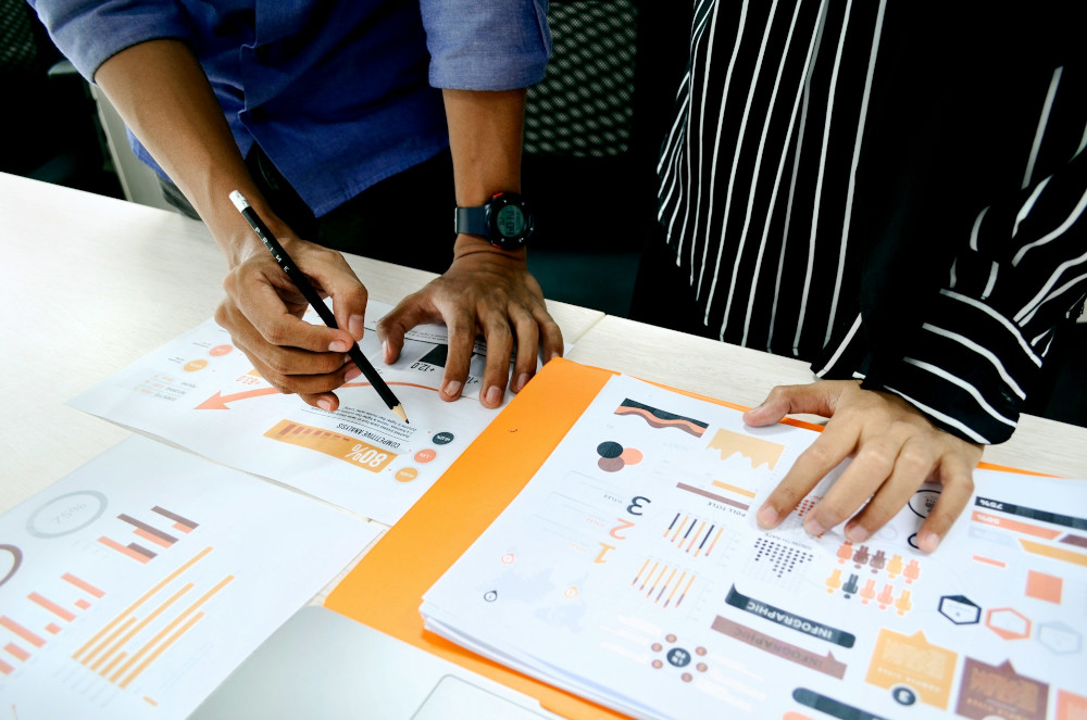 Colleagues viewing process metrics printouts