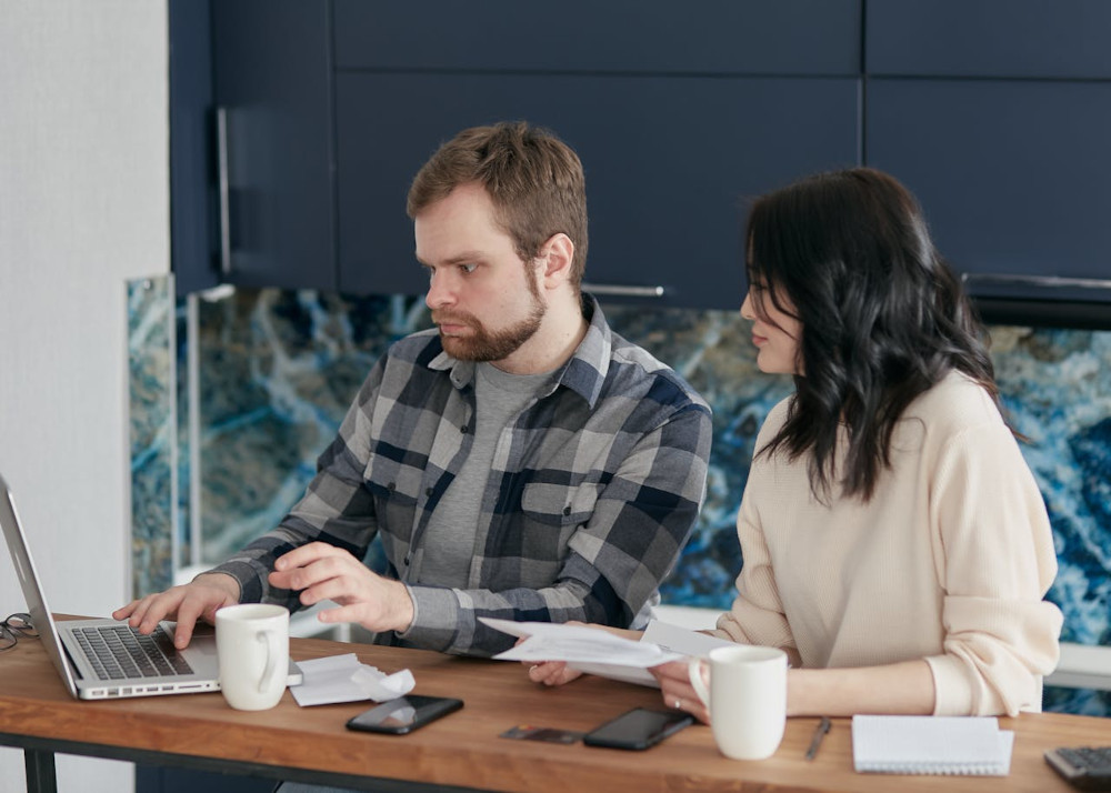 Colleagues review the process flow on a laptop